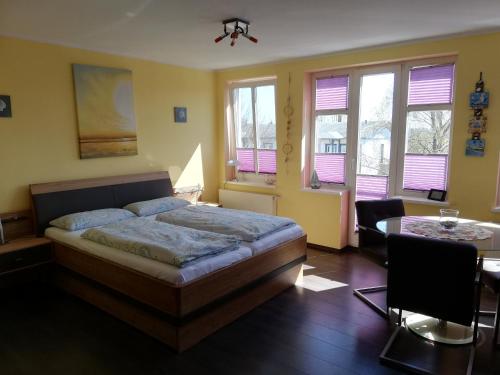 バンシンにあるAppartement Blaue Welleのベッドルーム1室(ベッド1台、テーブル、窓付)
