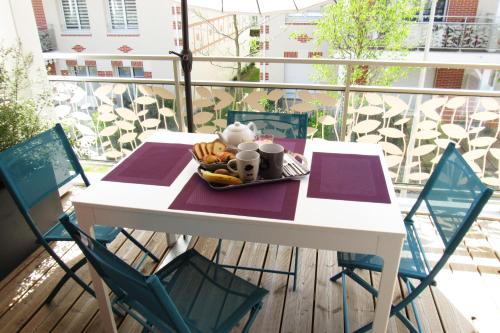 a table with a plate of food on a balcony at Appartement 42m² - 1 chambre 2 personnes à Pornic in Pornic