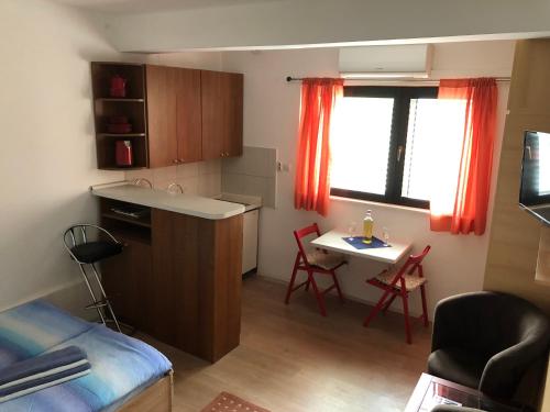 um pequeno quarto com uma cozinha e uma mesa em Apartment Centar em Split