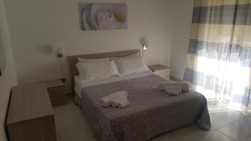 a bedroom with a bed with two towels on it at Giusy's Place 1 in Campofelice di Roccella