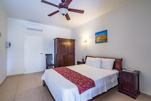 a bedroom with a bed and a ceiling fan at Casa Amalia in Willemstad