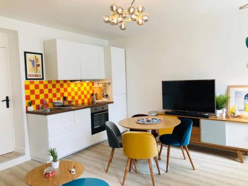 une cuisine avec une table et des chaises dans une pièce dans l'établissement Relais Cocorico Fondary Apartment Eiffel Tower District, à Paris