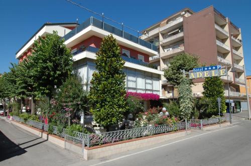 um edifício com árvores e flores em frente em Hotel Adele em Bellaria-Igea Marina