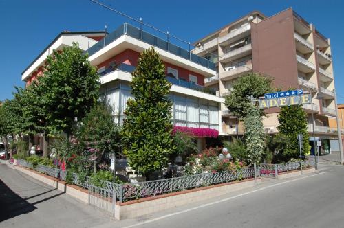 un edificio con alberi e fiori di fronte di Hotel Adele a Bellaria-Igea Marina