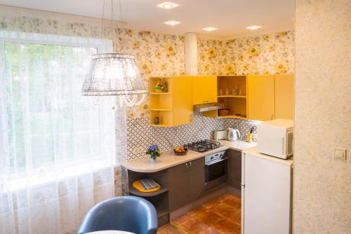 a kitchen with yellow cabinets and a white refrigerator at Apartment on Meža prospekts in Jūrmala