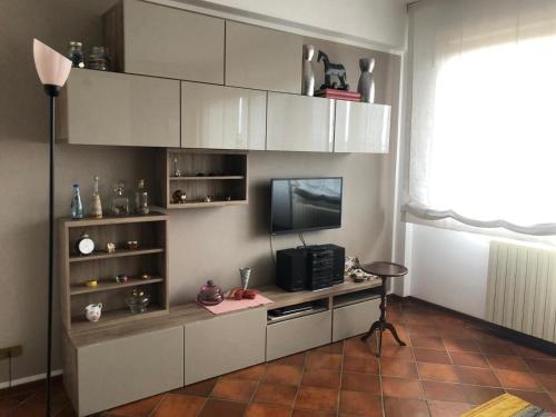- un salon avec une télévision et des placards blancs dans l'établissement Appartamento Cristina, à Piombino