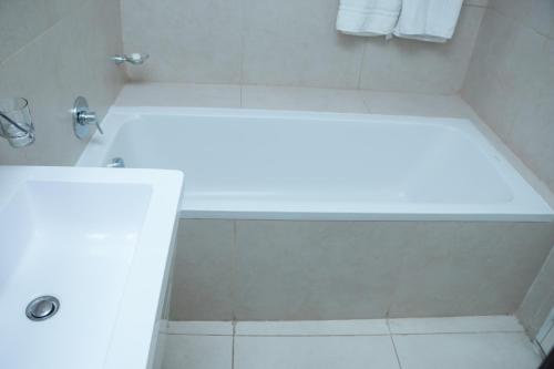 a bathroom with a shower with a white tub at 90 Independence Avenue in Accra