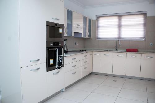 a kitchen with white cabinets and a black appliance at 90 Independence Avenue in Accra