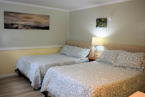 a hotel room with two beds and a painting on the wall at Blackbeard's Lodge in Ocracoke