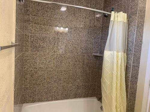 y baño con ducha y cortina de ducha. en Wagon Wheel Motel, en Salinas