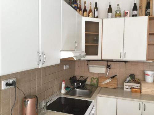 a kitchen with white cabinets and a sink at JUDIA in Litomyšl