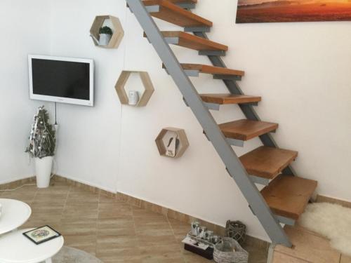a living room with a staircase with a tv at JUDIA in Litomyšl