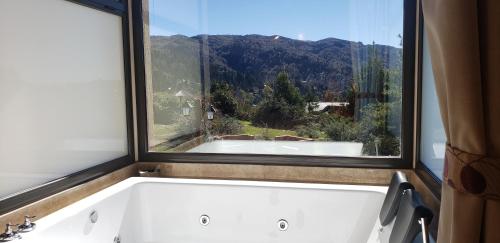 a bath tub in a bathroom with a window at Aires Serranos - Suites in La Cumbrecita