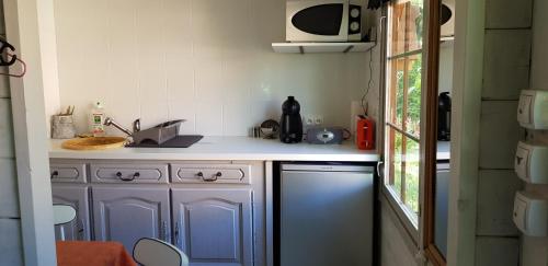 a small kitchen with a sink and a microwave at La cabane de Pioupiou in Fayence