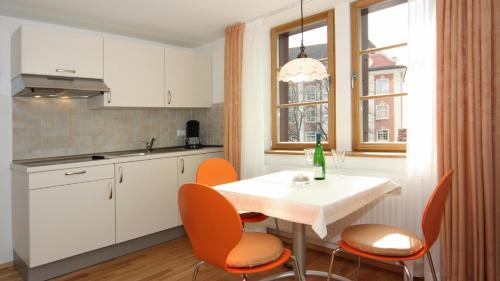 a kitchen with a white table and orange chairs at Ferienwohnung Braun in Meersburg