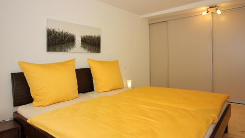 a bedroom with yellow pillows and a bed at Ferienwohnung Braun in Meersburg