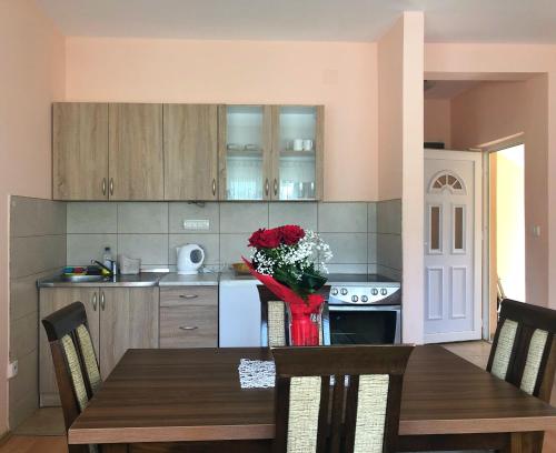 una cucina con tavolo e vaso di fiori di Apartments Simic a Kamenari