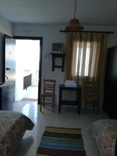 a bedroom with a bed and a table and chairs at Olga Paltsi Rooms in Paltsi Pilion