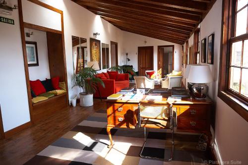 a living room with a desk and a red couch at Platanera Suites in Icod de los Vinos