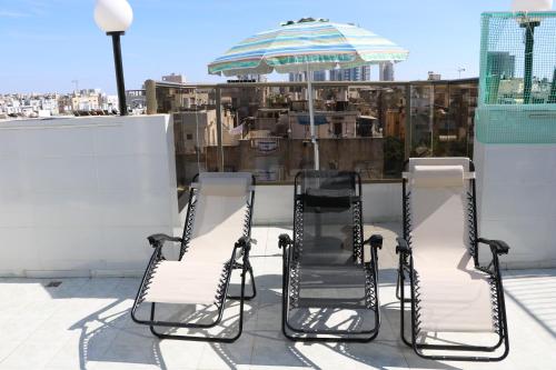 two chairs and an umbrella on a roof at Beutifull view of batyam in Bat Yam