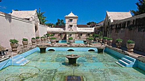 a house with a courtyard with a swimming pool at Mitra Hotel in Yogyakarta