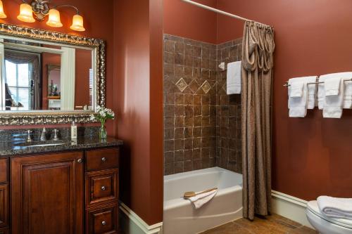 a bathroom with a tub and a sink and a mirror at The Inn on West Liberty in Savannah
