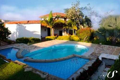 a swimming pool in the yard of a house at Aires del Sauzalito in Barichara