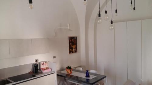 a kitchen with white walls and a black counter top at La casetta di Flavia :guest house molto accogliente in Rionero in Vulture