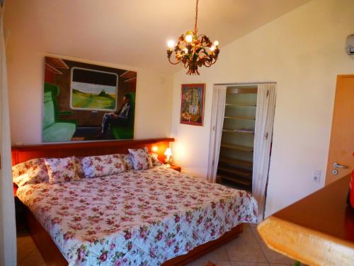 a bedroom with a bed and a chandelier at Casa del Arte in L'Ametlla de Mar
