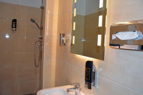 a bathroom with a sink and a shower with a mirror at Ambiente in Soltau