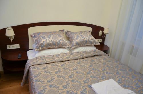 a bedroom with a bed with a wooden headboard and pillows at Apartment nr. 8 in Odesa