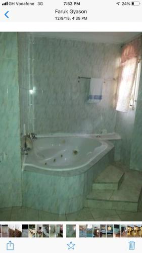 a bathroom with a bath tub in a room at Gya-son Royal Guest House in Kumasi