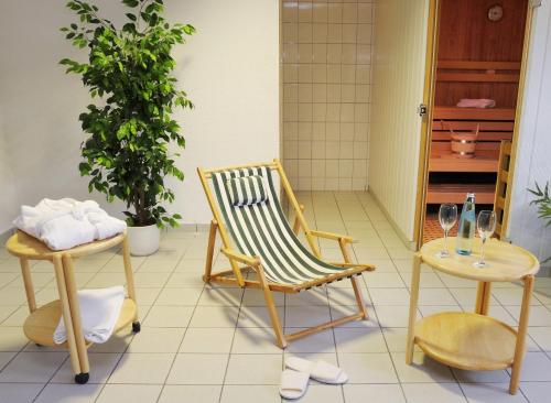 Zimmer mit einem Stuhl und einem Tisch mit Weingläsern in der Unterkunft Hotel Landgasthof Kranz in Hüfingen