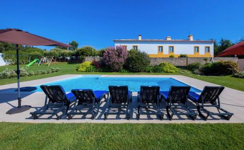 a group of chairs sitting next to a swimming pool at A Casa da Andorinha in Salir de Matos