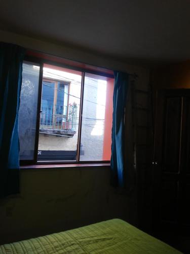 a bedroom with a window with a view of a balcony at Loft Calicanto con Cochera in Guanajuato