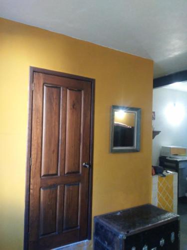 a room with a wooden door and a yellow wall at Loft Calicanto con Cochera in Guanajuato