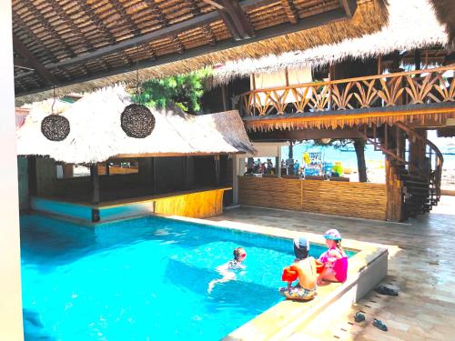three children playing in a swimming pool in a resort at Samba Villas Beachfront View in Gili Trawangan