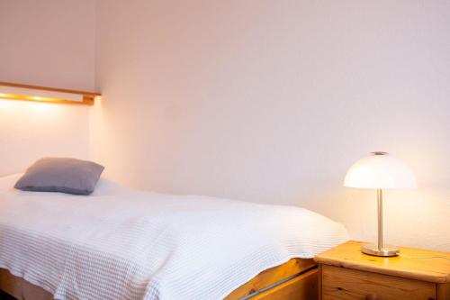 a bedroom with a bed and a lamp on a nightstand at Haus am Deich Wohnung 5 in Dahme
