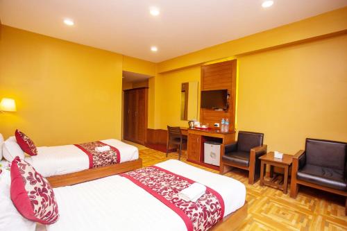 a hotel room with two beds and a desk at Hotel Iceland in Pokhara