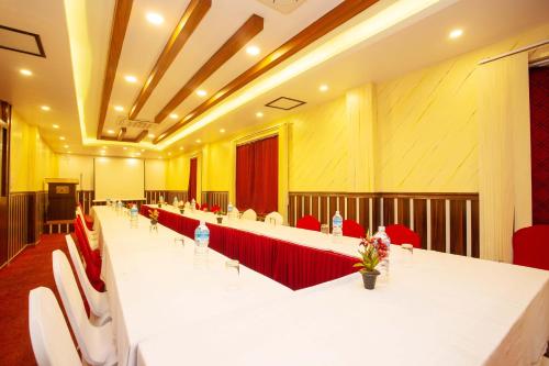 a large conference room with a long table and red chairs at Hotel Iceland in Pokhara