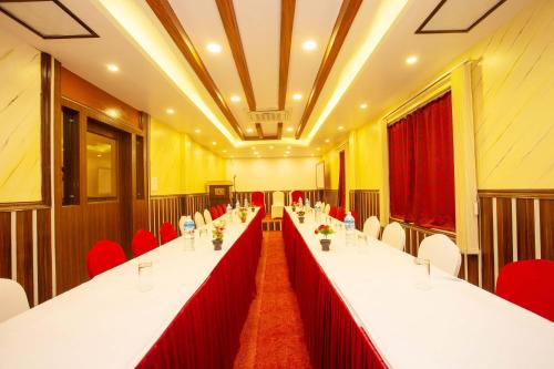 a long table with red chairs in a conference room at Hotel Iceland in Pokhara