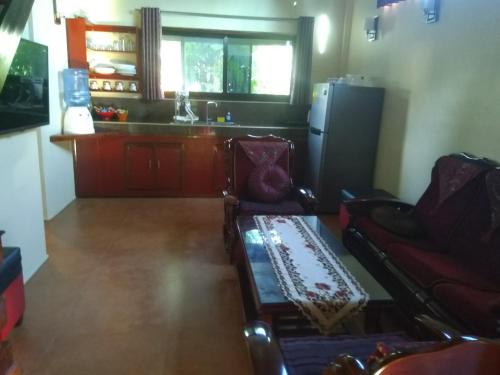 a living room with two chairs and a refrigerator at Siargao Sunset Bay Beach Villas in General Luna