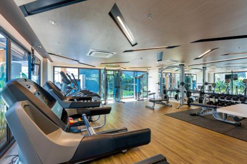 a gym with treadmills and ellipticals in a building at The Nature Phuket - SHA Extra Plus in Patong Beach