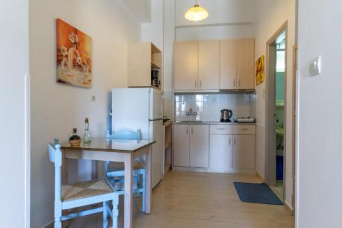 a small kitchen with a table and a refrigerator at Eleni Goumenaki Plakias Studios in Plakias