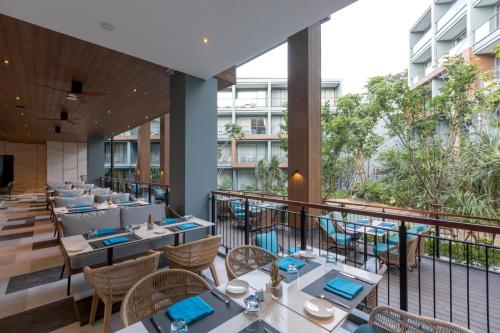 a restaurant with tables and chairs on a balcony at The Nature Phuket - SHA Extra Plus in Patong Beach