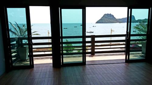 an open door to a view of the ocean at Zea Zide Hotel in Prachuap Khiri Khan