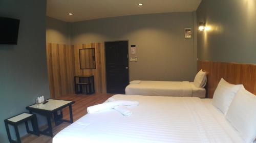 a hotel room with two beds and a table and a bed at Zea Zide Hotel in Prachuap Khiri Khan