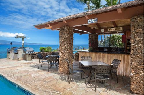 a restaurant with a table and chairs next to a pool at Noelani 304 in Kahana