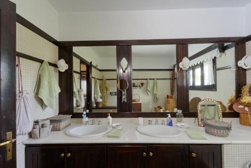 een badkamer met 2 wastafels en een grote spiegel bij Farm Villa Dova in Vathírrevma