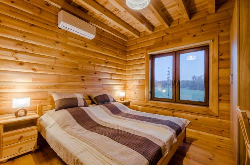 Una cama o camas en una habitación de Domki nad Jeziorem